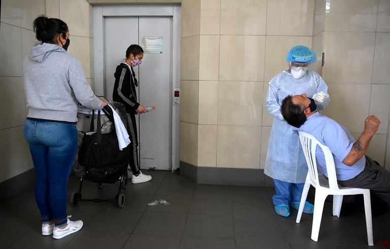 عامل صحي يأخذ مسحة لفحص كورونا