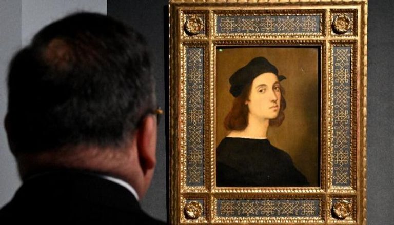 زائر أمام لوحة بورتريه ذاتي لرافايلو في معرض مكرس لفنان النهضة في روما