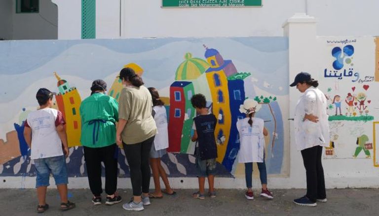 مجموعة من الأطفال أمام إحدى جداريات أصيلة