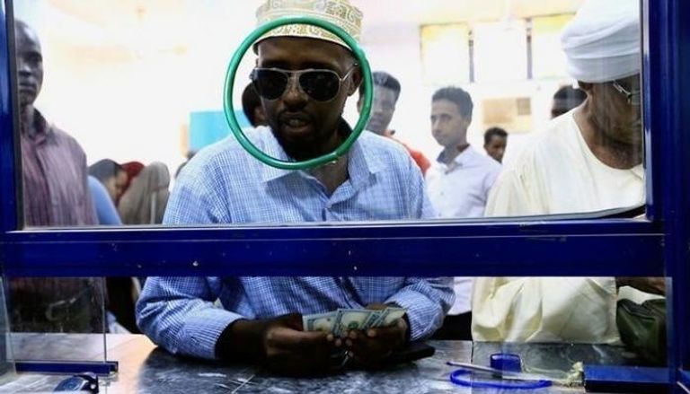 سوداني يشتري دولارات من أحد المصارف - رويترز