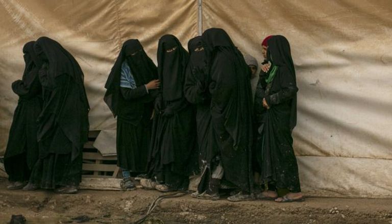 نساء يصطفن للحصول على مساعدة في مخيم الهول شمال سوريا 