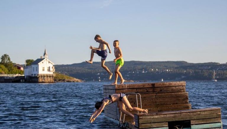 أطفال يقفزون في مياه مضيق أوسلو بالعاصمة النرويجية – أ ف ب