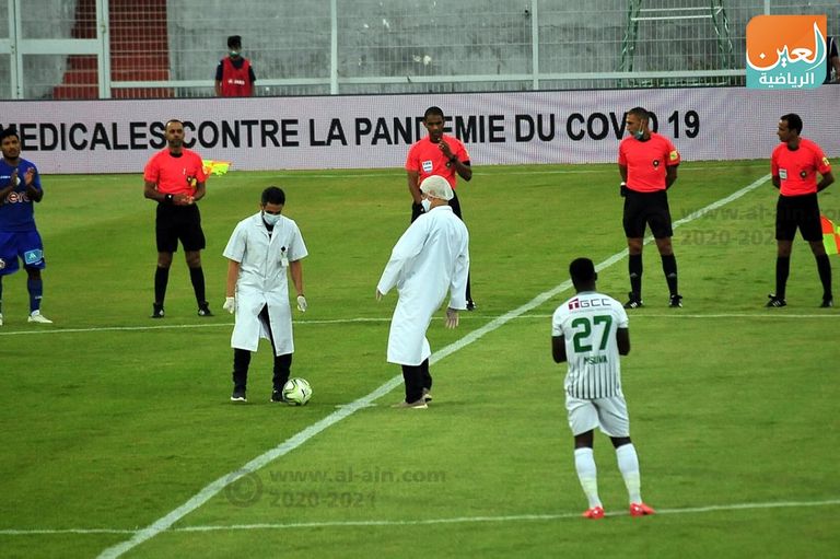 طبيبان مغربيان يقومان بركلة بداية عودة الدوري المغربي، بين فريقي الدفاع الحسني الجديدي والرجاء المغربي، يأتي ذلك للتأكيد على الدور الذي لعبه الأطباء في مواجهة جائحة كورونا مباراة الرجاء البيضاوي والدفاع الحسني الجديدي