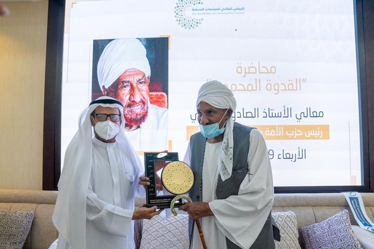 الدكتور علي راشد النعيمي، رئيس المجلس العالمي للمجتمعات المسلمة، يهدي درع المجلس للإمام الصادق المهدي الصادق المهدي إلى جوار الدكتور علي النعيمي