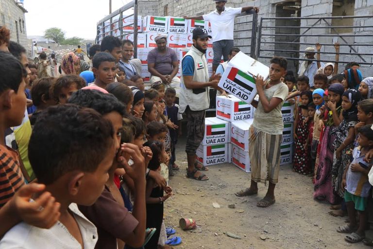 عضو فريق الهلال الأحمر الإماراتي يتحدث مع طفلة يمنية