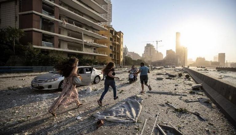 لبنانيون يركضون عقب الانفجار الذي خلف دمارا واسعا في بيروت