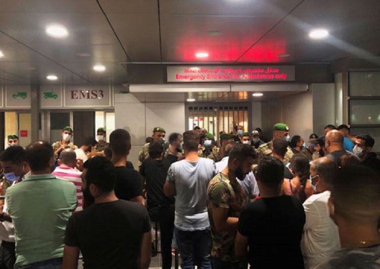 شباب وعناصر أمن يحملون إحدى ضحايا الانفجار