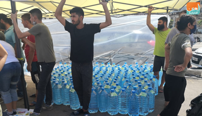 شباب يزيلون الزجاج المتناثر في شوارع بيروت