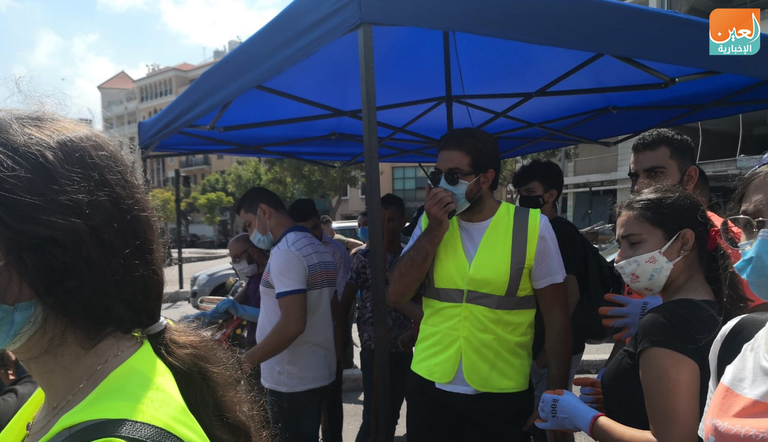 شباب يزيلون الزجاج المتناثر في شوارع بيروت