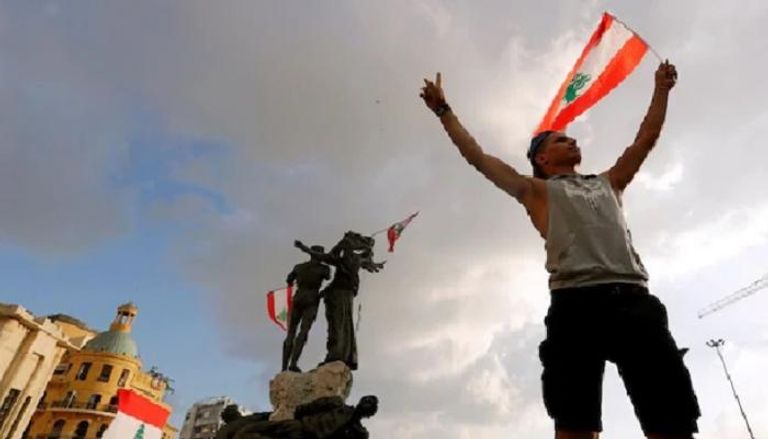 متظاهرون يرفعون علم لبنان في بيروت 
