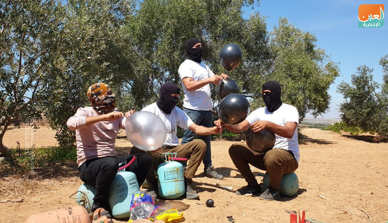 عناصر من حركة حماس تعد بالونات حارقة 