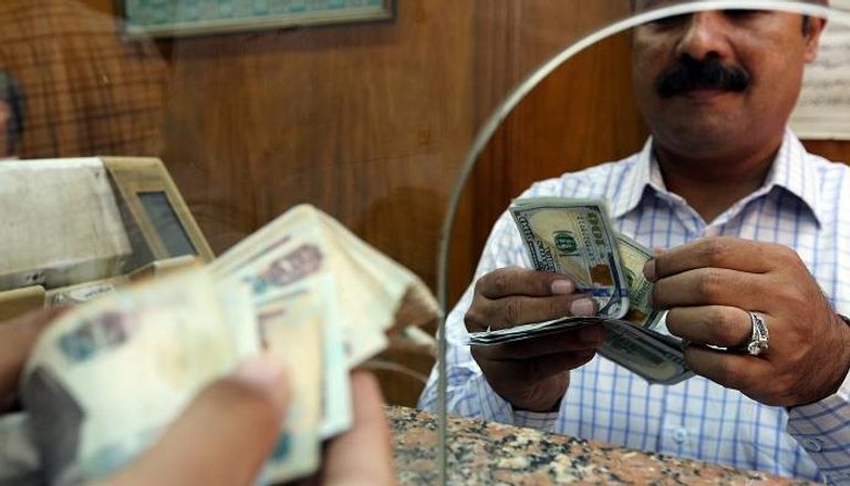 مصري يقوم بشراء دولارات من مكتب صرافة بالقاهرة