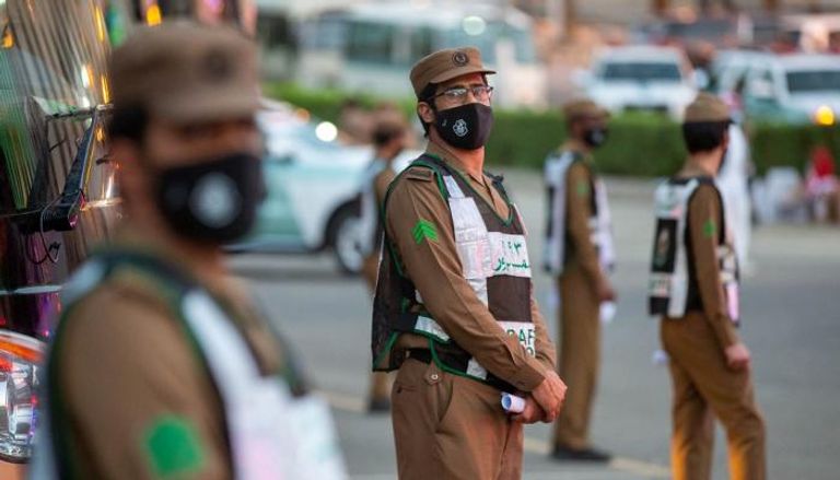 رجال مرور يرتدون كمامات للوقاية من فيروس كورونا في السعودية