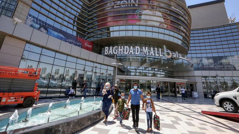 أشخاص يضعون كمامات خلال تجولهم بمركز تسوق