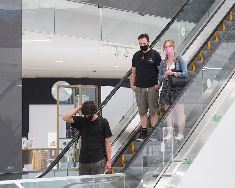 أشخاص يضعون كمامات خلال تجولهم بمركز تسوق