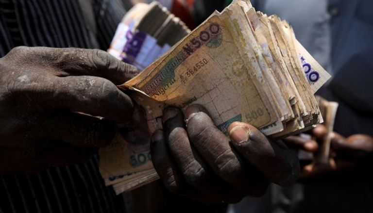 نجيري يحصي أوراق نقد العملة المحلية 
