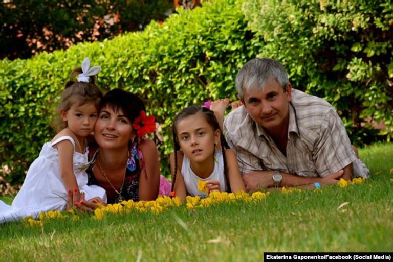 والدة الطيار الأوكراني تحمل صورته وزوجته إلى يمينها - أرشيفية