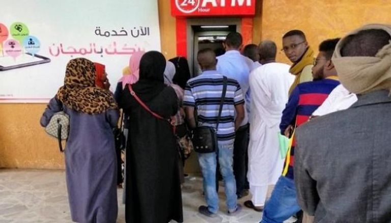 سودانيون ينتظرون دورهم على ماكينة الصراف الآلي