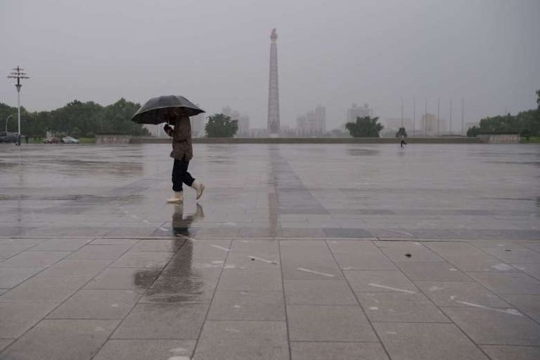 مارة يحتمون بالمظلات من الأمطار الغزيرة في اليابان