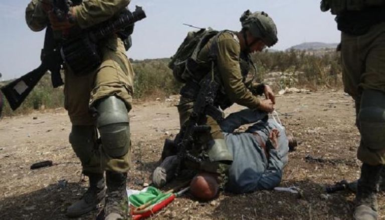 جندي إسرائيلي يضع ركبته فوق رقبة خيري حنون 