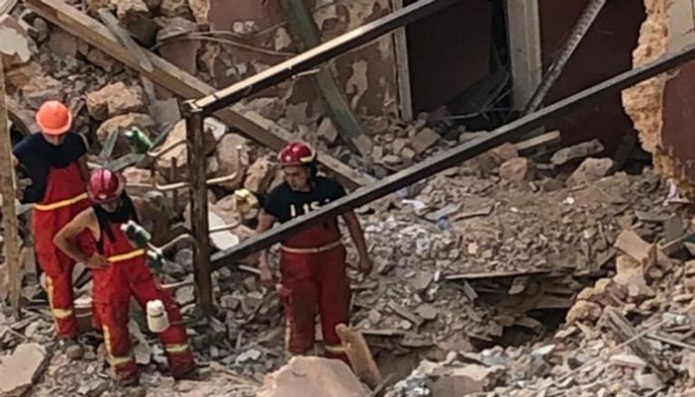 عمال الإنقاذ ينقبون وسط أنقاض مبنى منهار في بيروت