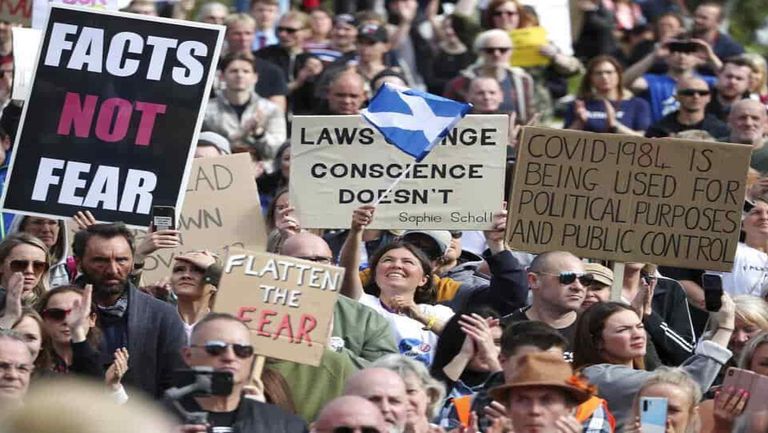 مظاهرات ضد إجراءات كورونا إجراء مسحة كورونا لأحد المصابين - رويترز