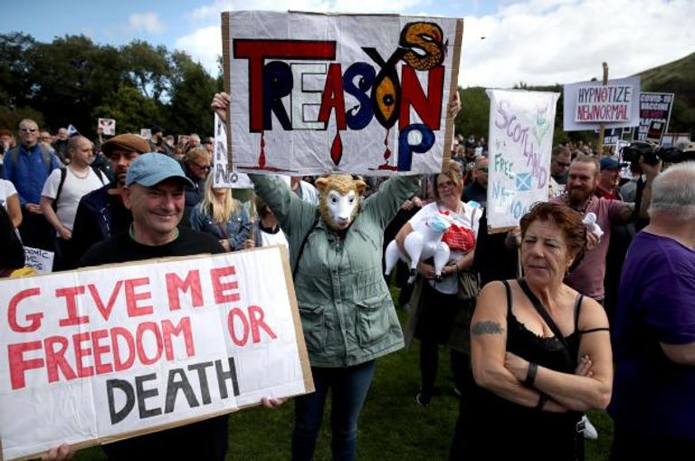 مظاهرات ضد إجراءات كورونا إجراء مسحة كورونا لأحد المصابين - رويترز