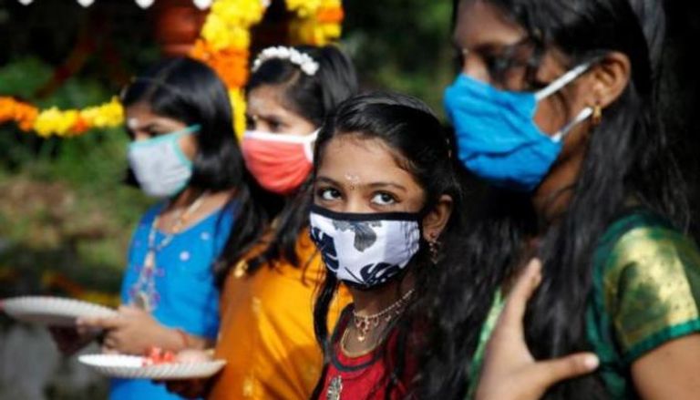 فتيات هنديات يرتدين الكمامة للوقاية من فيروس كورونا