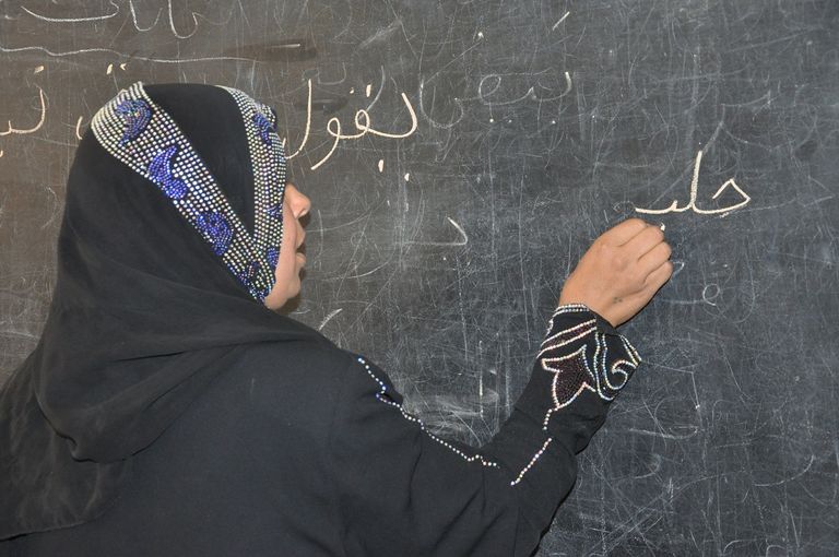 سيدة تتعلم الكتابة ضمن فصول تعليم الكبار