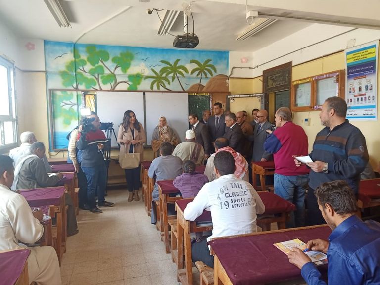 سيدة تتعلم الكتابة ضمن فصول تعليم الكبار