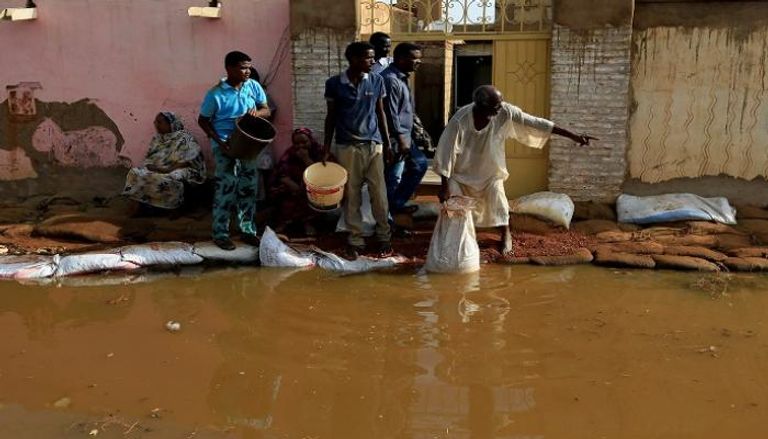 سودانيون يحاولون إنقاذ منازلهم من مياه الفيضانات