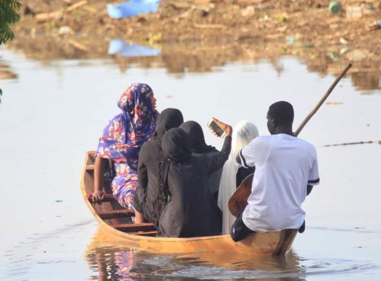 فتاة تلتقط سيلفي من مركب مع نساء أخريات أثناء عملية إنقاذهم من فيضانات السودان