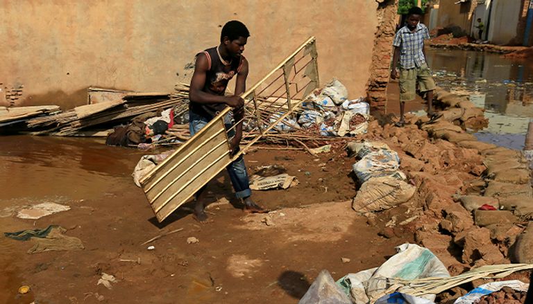 سوداني يضع حواجز لمنع وصول الفيضانات إلى منزله
