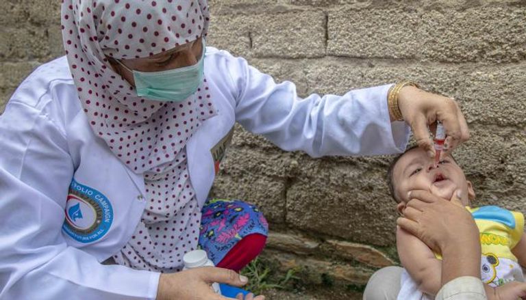 طبيبة تقوم بتطعيم طفل باكستاني