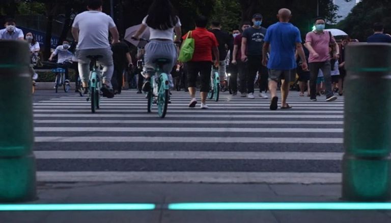 إشارات المرور مضيئة أثناء عبور صينيون الطريق إشارات مرور خاصة بمدمني الهواتف المحمولة