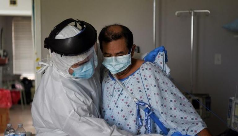 طبيب يساعد أحد المصابين بفيروس كورونا في الولايات المتحدة
