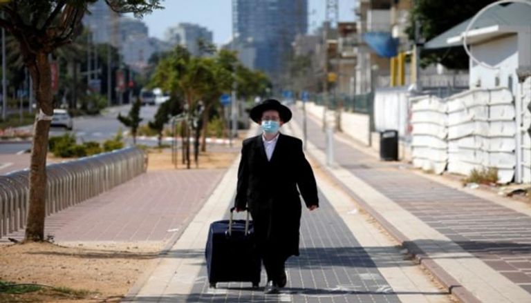 شخص يرتدي كمامة للوقاية من عدوى كورونا بإسرائيل