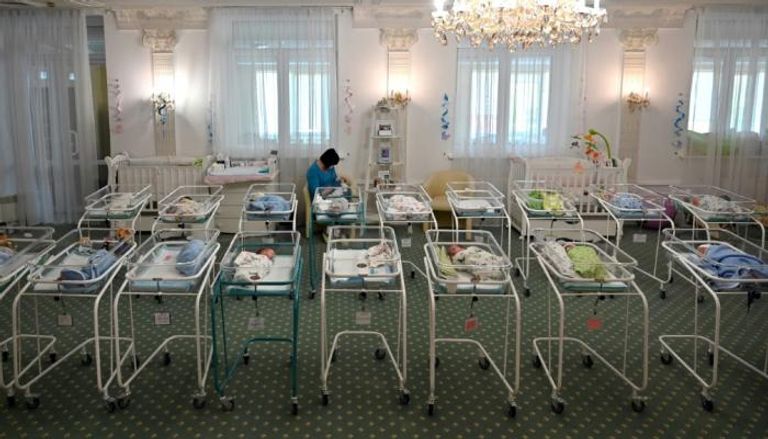 ممرضة تعتني بمواليد جدد من بين 100 طفل ولدوا لأمهات بديلات في أوكرانيا