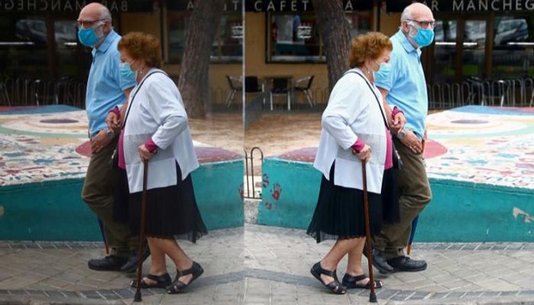 مسنان يرتديان الكمامة في العاصمة الإسبانية مدريد