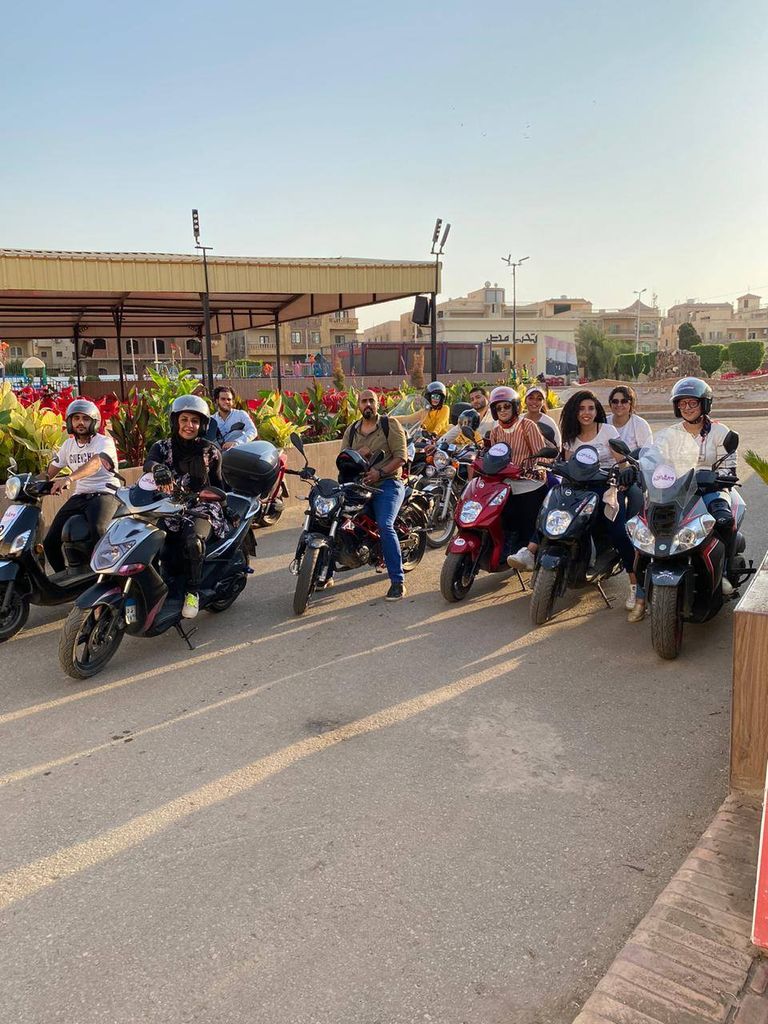 مجموعة من الشباب المنضمين لمبادرة "سوقي سكوتر" لتعليم الفتيات قيادة السكوتر الشابة المصرية ولاء زهير مع إحدى المتدربات