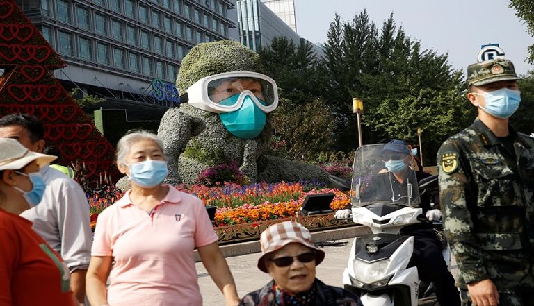 سيدات يرتدين كمامات للوقاية من عدوى كورونا بالصين