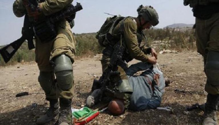 جندي إسرائيلي يضع ركبته فوق رقبة خيري حنون