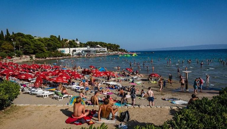 يستمتع السباحون بأخذ حمام شمسي على شاطئ باكفيس بكرواتيا