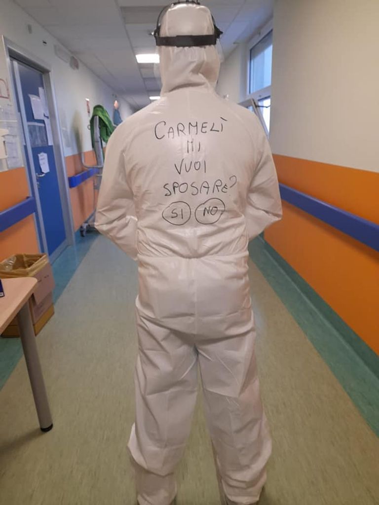 الممرض الإيطالي طالباً يد حبيبته بالكتابة على بدلة مكافحة كورونا