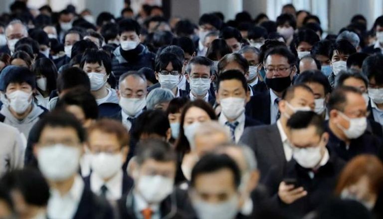 أشخاص يرتدون كمامات للوقاية من فيروس كورونا في اليابان
