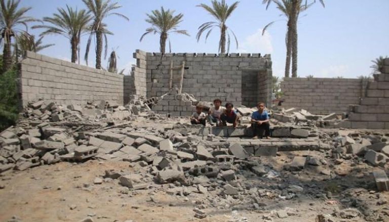 أطفال يمنيون على أنقاض منزل دمره الحوثيون بالحديدة