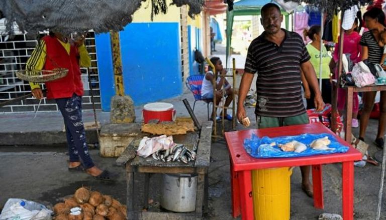تاجر فنزويلي يبيع الدجاج في سوق بمدينة جويريا شمال فنزويلا – أ ف ب