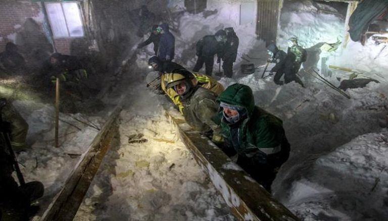 عمال الإنقاذ في موقع الانهيار الثلجي