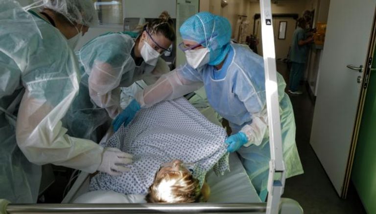 ممرضات يعتنين بمصاب بكورونا في مستشفى فرنسي