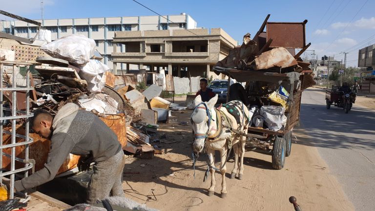 عاملان يجمعان قطع البلاستيك من النفايات تمهيدًا لإعادة تدويرها
